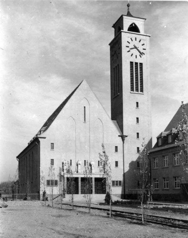 Schwarz-Weiß-Bild der Lutherkirche in Halle/Saale. Neben einem Kirchengebäude mit hohem Satteldach steht ein Glockenturm mit Uhr.