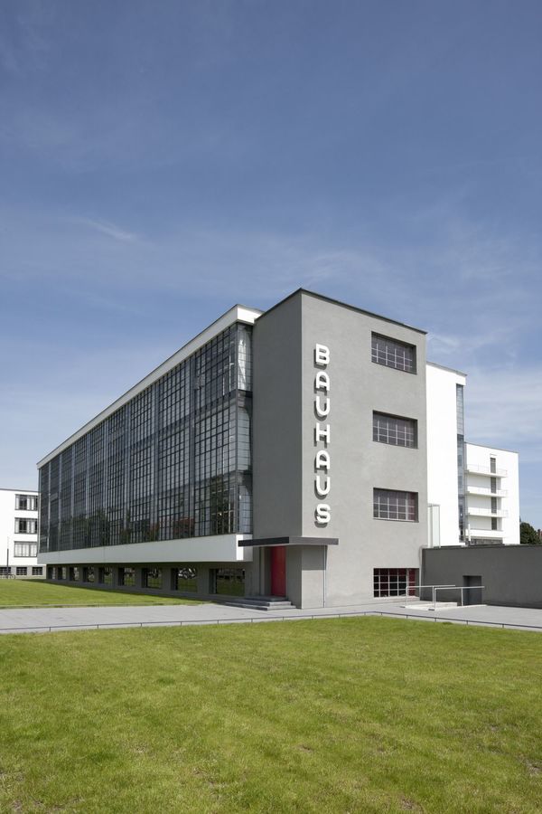 Das Bauhausgebäude mit seiner Glasvorhangfassade vor blauem Himmel