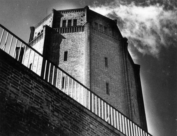 Schwarz-Weiß-Bild eines Wasserturms, des Wasserturm Süd in Halle/Saale. Der Wasserturm ist aus der Froschperspektive fotografiert und ragt aus Sicht des Betrachters weit in die Höhe.