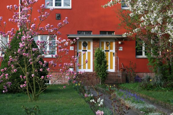 Zwei Haustüren in einer rot verputzten Fassade