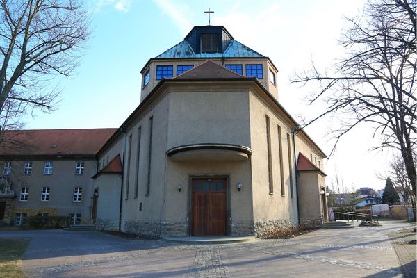 Blick auf ein Kirchenportal mit darüber ragendem Dachaufbau